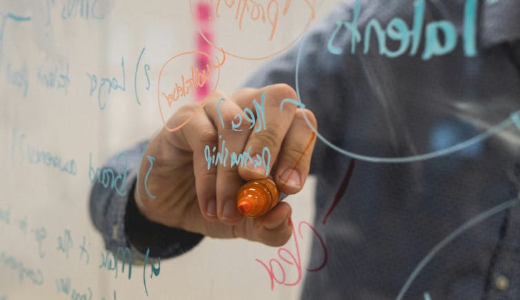 Person writing on a whiteboard
